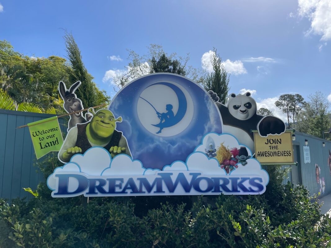 Dreamworks themed sign featuring shrek, donkey, and kung fu panda characters under a moon silhouette, with the text "welcome to our land" and "join awesomeness.