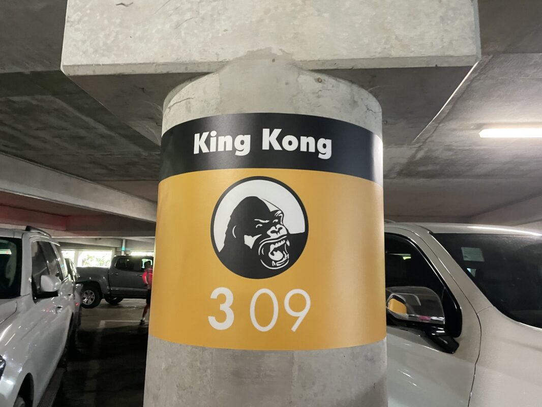 Concrete pillar in Universal Orlando parking garage with a black and yellow sign that features an image of King Kong, text that reads "King Kong," and the number 309.