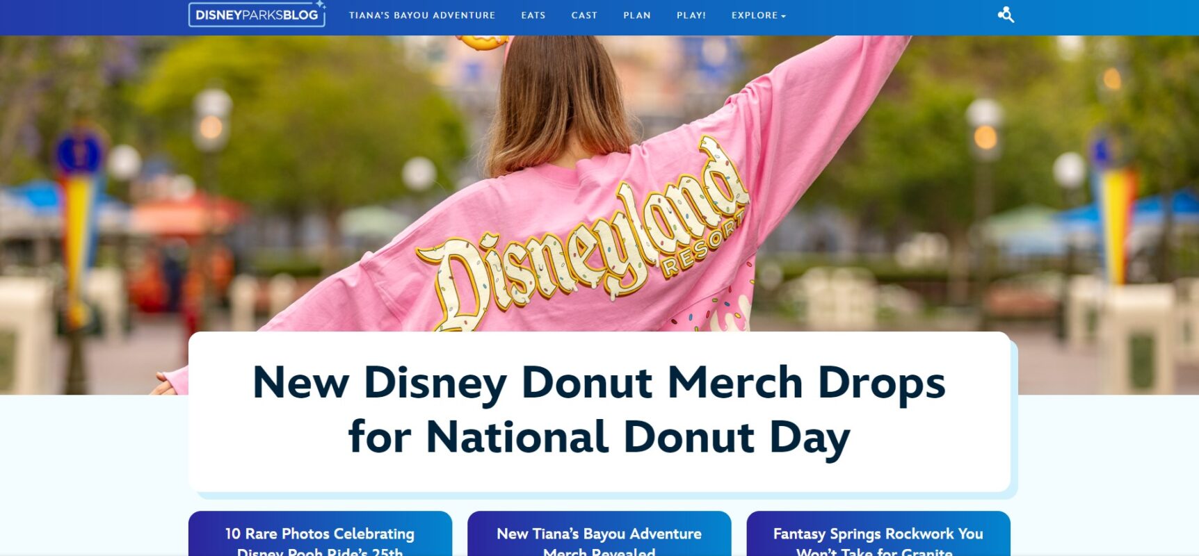 A person wearing a pink jacket with "Disneyland Resort" on the back faces away. Text reads, "New Disney Donut Merch Debuts for National Donut Day." Website navigation is visible at the top. Discover all the details on the Disney Parks Blog!