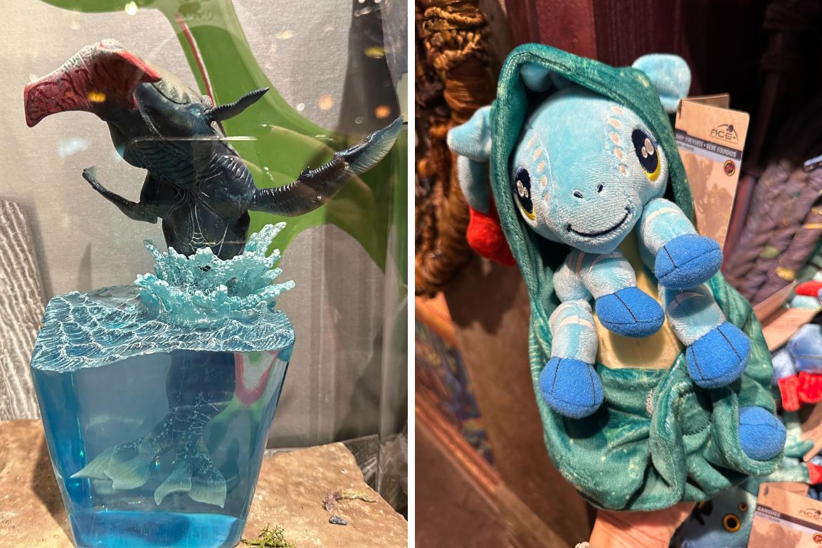 Side-by-side display of two items: a figure of the Loch Ness Monster emerging from water inside a glass cube, and a plush toy of a blue dragon with yellow eyes, wrapped in a green cloak.