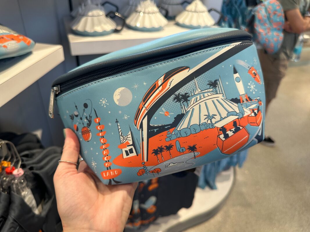 A blue Tomorrowland belt bag with orange and white artwork depicting spacey images and attractions