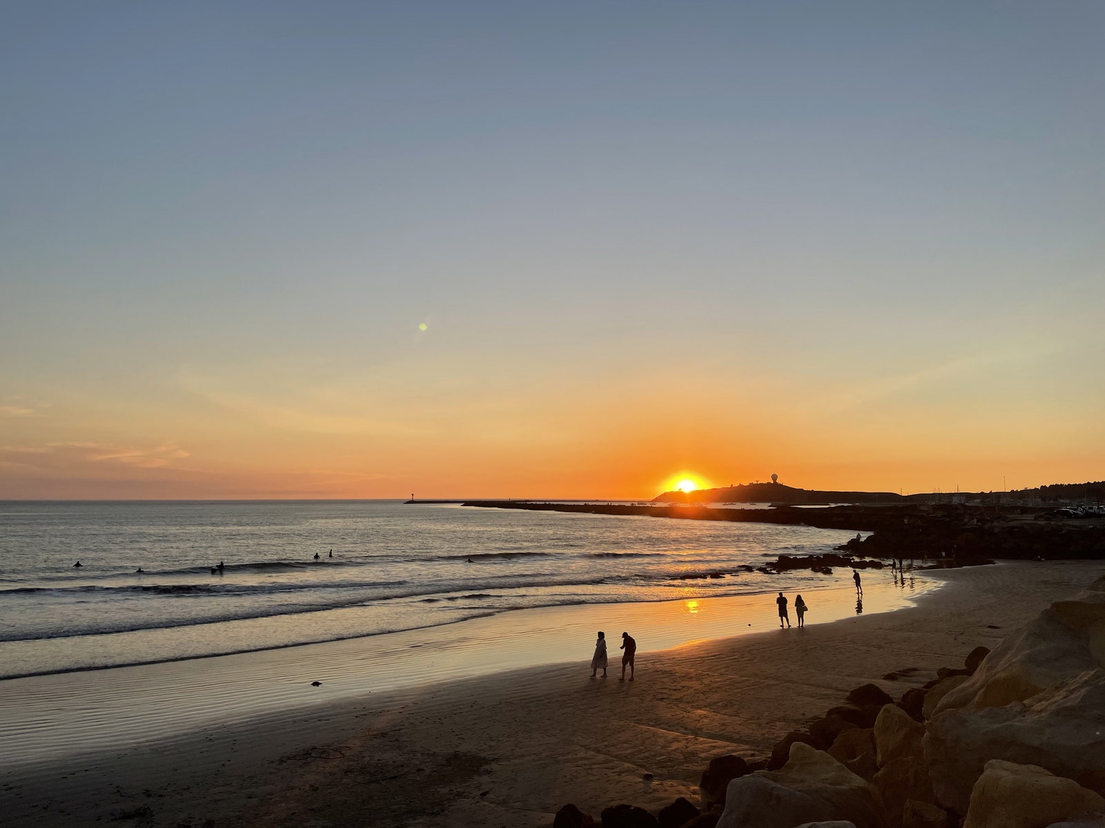 Image may contain Human Person Light Flare Nature Outdoors Sunlight Sunset Dusk Sky Dawn Red Sky and Shoreline