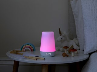 Hatch Rest 2nd Gen sitting on kid's bedside table glowing pink