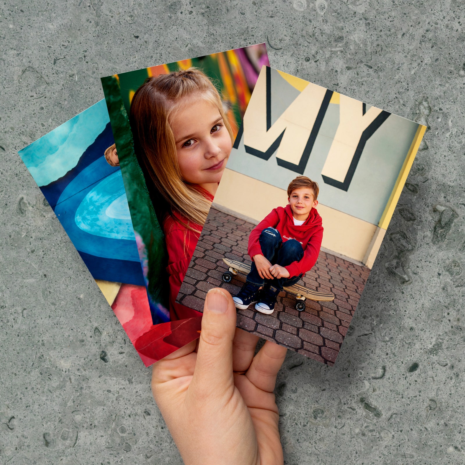 Person's hand holding printed photographs