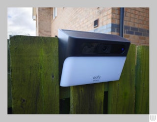 Angular solar light attached to green fence