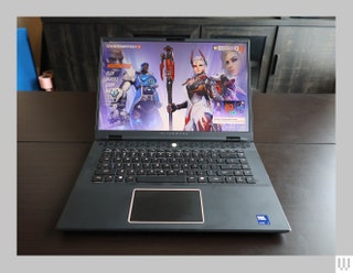 Front view of black laptop on dark wood surface with a menu screen