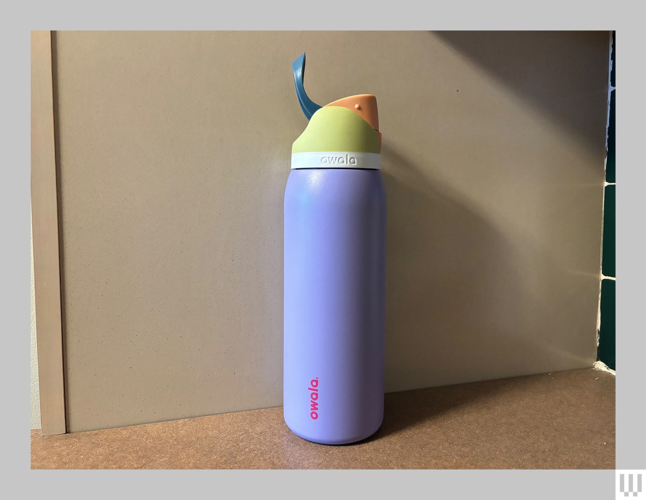 Brightly colored reusable water bottle with a cylindrical base and angled spout