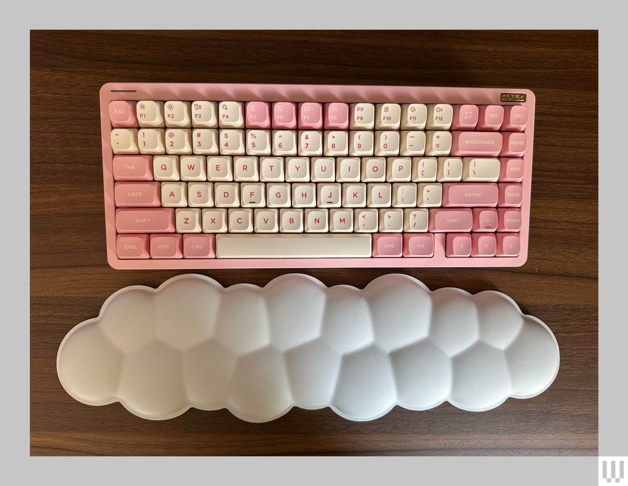 Pink and white computer keyboard beside a fully wristpad shaped like a white cloud