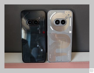 The backsides of two mobile phones showing their cameras. A black phone on the left and silver phone on the right.