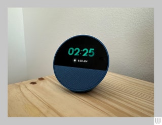 Semisphere Echo Spot device with a screen on the front displaying the current time as well as the time the alarm is set for.