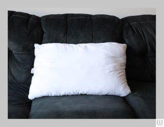 White bed pillow on a dark couch