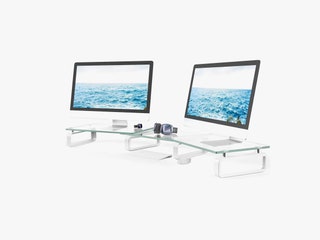 Two clear stands with silver supports side by side each holding up a computer monitor