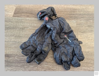 Montane Prism Gloves in black crinkled and sitting on a wooden surface