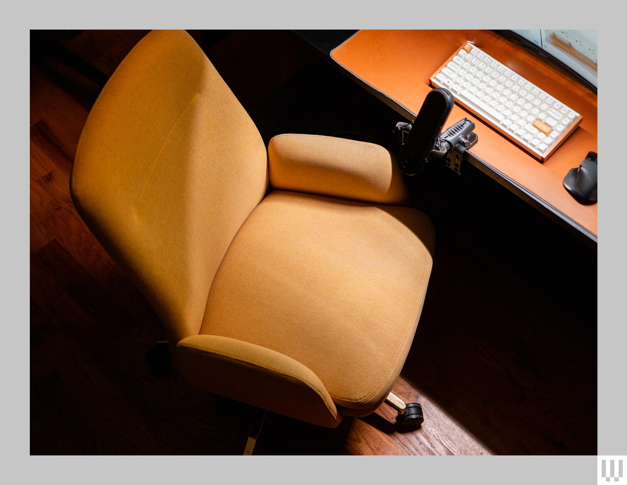 Overhead view of Branch Softside, a high-back office chair in yellow, near a dimly lit desk and computer keyboard