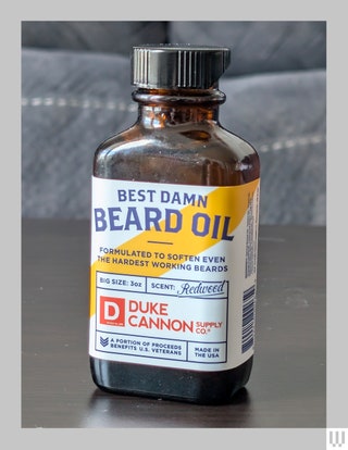 Duke Cannon Supply Co Best Damn Beard Oil a dark bottle with a label for the redwood scent