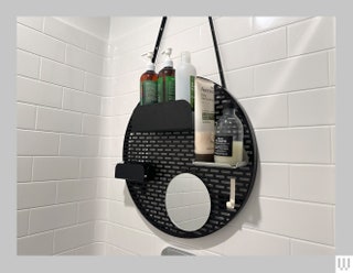 Quiet Town The Spot a black circular grate hanging from a showerhead with modular shelves and a mirror