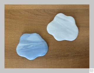 East Fork Glass Cloud Coasters with one in blue and one in white both on a wooden surface