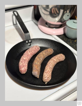 Merten  Storck 10Inch Frying Pan Skillet on a white stove with three sausages inside