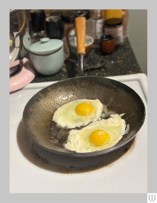 Kehoe Carbon Cookware 10Inch Frying Saucepan on a white stove with two eggs cooking inside the pan