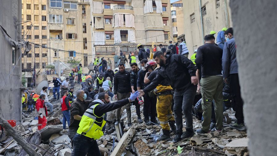 Photo: Rescuers search for victims at the site of an Israeli airstrike that targeted a building in ...