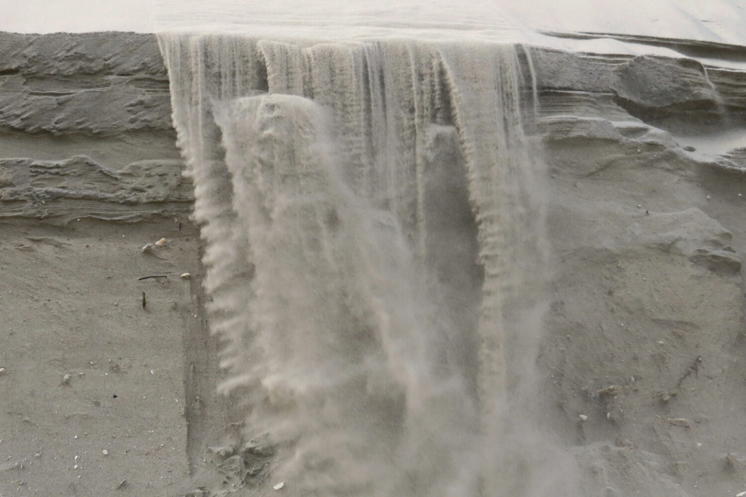 Sand cascades down the badly eroded face of a dune in North Wildwood, N.J. on Feb. 24, 2023. (AP Ph...