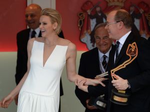 Prince Albert II of Monaco (R) and his wife Princess Charlene share a laugh on the podium during the Monaco Formula One Grand Prix at the Monaco street circuit in Monte-Carlo on May 24, 2015. AFP PHOTO / BORIS HORVAT (Photo credit should read BORIS HORVAT/AFP/Getty Images)