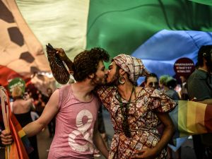 People kiss during a gay parade on Istiklal Street, the main shopping corridor in Istanbul, on June 22, 2014, during the Trans Pride Parade as part of the Trans Pride Week 2014, which is organized by Istanbul's 'Lesbians, Gays, Bisexuals, Transvestites and Transsexuals' (LGBTT) solidarity organization. AFP PHOTO/BULENT KILIC