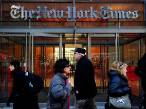People walk by the entrance to US newspaper 'The New York Times' in New York, March 8, 2011
