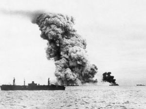 Smoke pours from an explosive carrying US ship in a naval convoy to Russia.