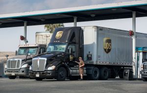 A UPS driver stands outside a truck at a stop in California.