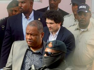 Sam Bankman-Fried dressed in suit escorted by Bahamian authorities