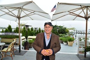 Ronald Perelman (bald middle aged man) smiling and holding a drink