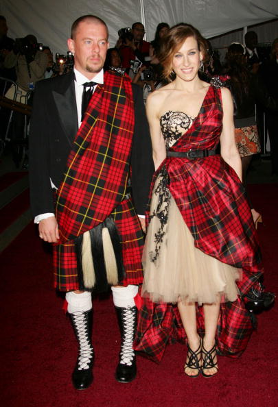 man and woman in matching red plaid kilt tartan outfits on red carpet 