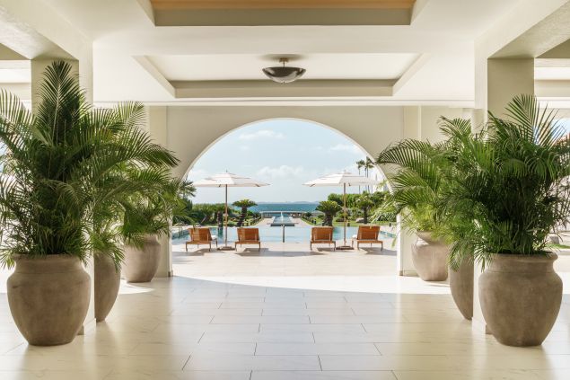 open archway of hotel with view of pool and ocean in caribbean