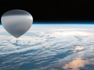 A large silver hot air balloon hovers above the earth's atmosphere in front of the blackness of space.