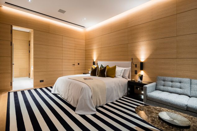 bedroom with striped floors, bed and brown walls 