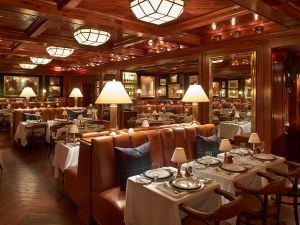 cozy wood paneled restaurant with leather banquettes and plaid pillows