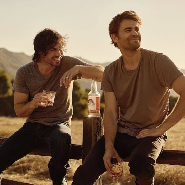 Simerhalder and Wesley drinking whiskey on a fence.