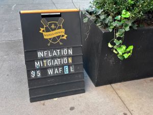 Humorous sign in front of Wafels and Dinges restaurant, Inflation Mitigation, Manhattan, New York