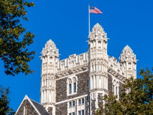 Grand building pictured against blue sky with American flag waving on top