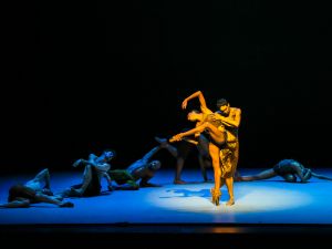 Dancers perform on a dimly lit stage