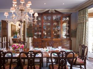 Intricately designed dining room with chandelier and china sets