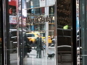 Entrance to Morgan Stanley headquarters, reflective doors show passerby walking dog
