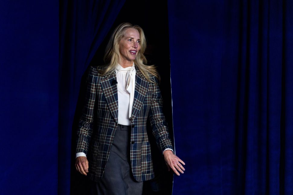 Blonde woman in suit walks on stage