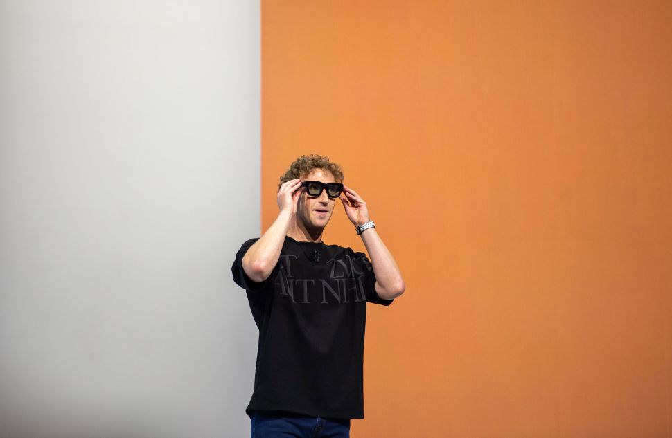 Man wearing sunglasses and black t-shirt stands on stage