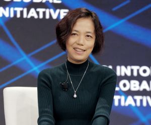 Woman in green shirt sits on panel