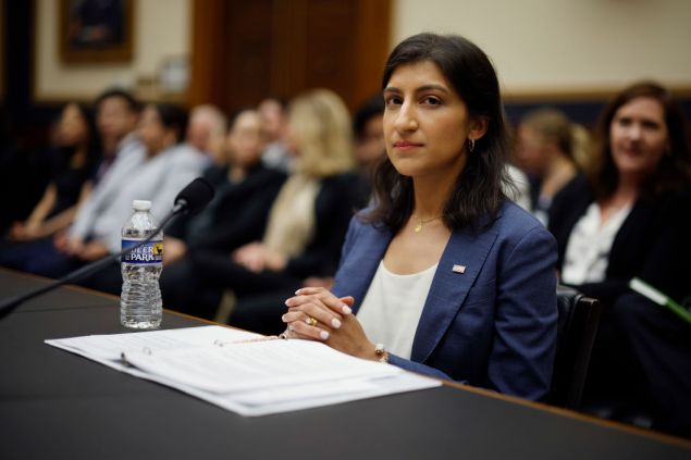 A woman in a suit sitting in a crowd.