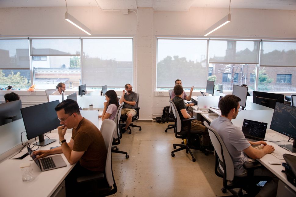 Rows of desks filled with workers in office building