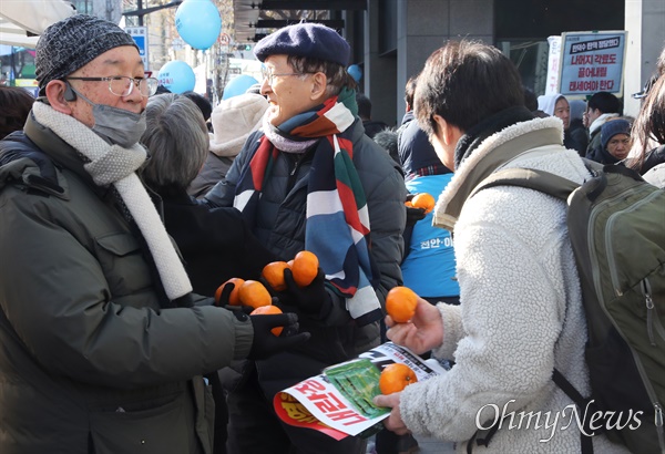  제주에서 감귤농장을 운영하는 윤순자씨의 지인들이 28일 오후 서울 안국역 일대에서 윤석열 파면 촉구 집회에 참석하는 시민들에게 귤 나눔을 하고 있다. 
