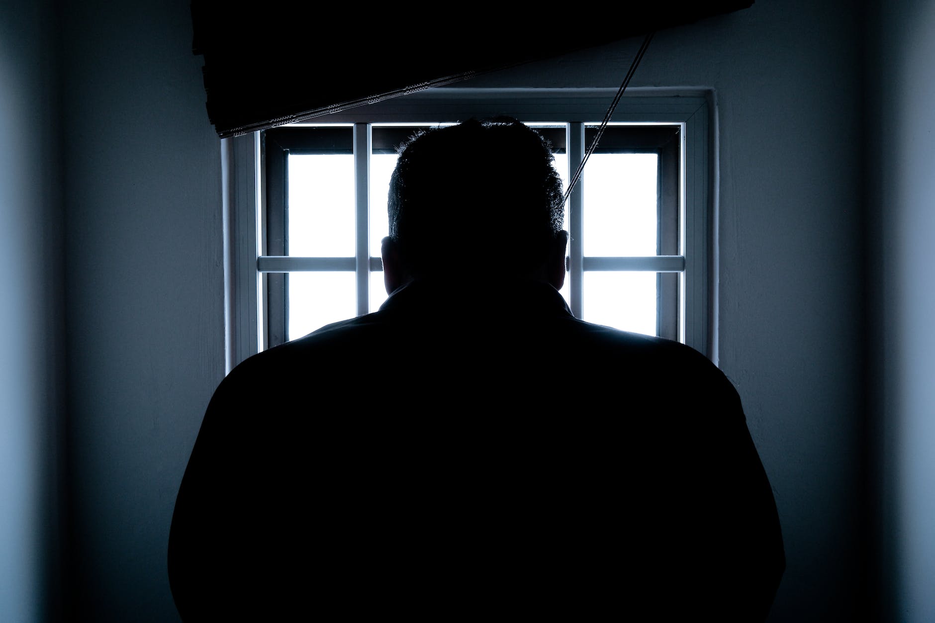 rear view of a silhouette man in window